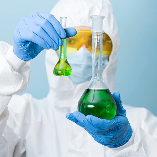 Cientista de visão frontal segurando produtos químicos verdes