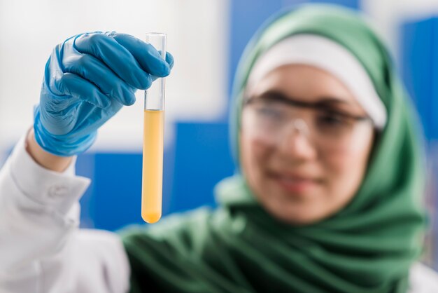 Cientista fêmea com hijab segurando substância