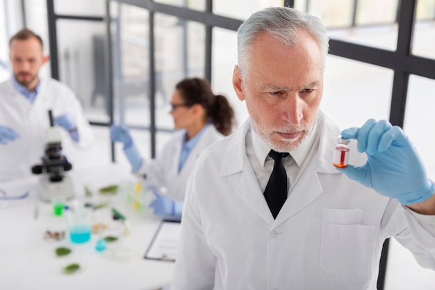 Foto grátis cientista segurando o frasco de tiro médio