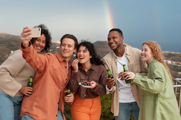 Cinco amigos tirando uma selfie durante a festa ao ar livre