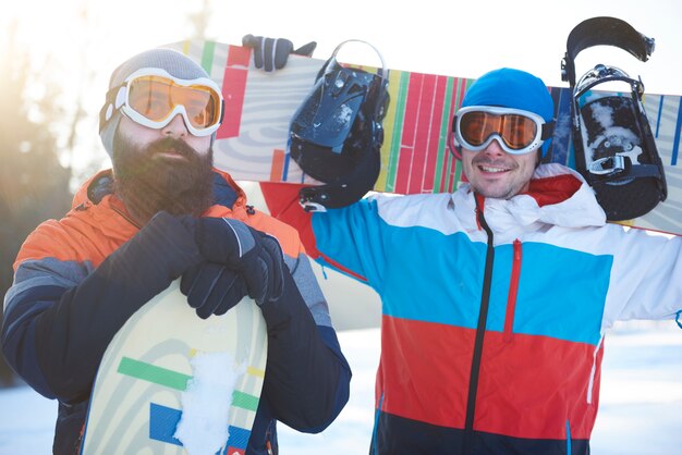 Cintura para cima de dois snowboarders masculinos