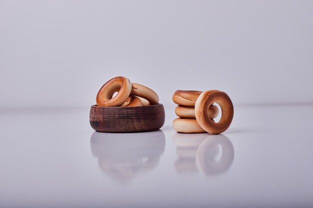 Circule bolachas ou pãezinhos em uma xícara de madeira isolada no meio do.