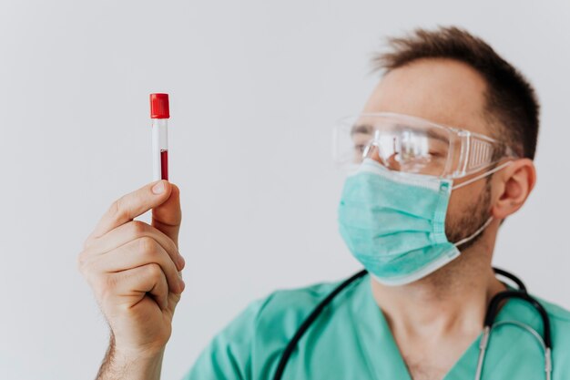 Cirurgião usando máscara segurando um tubo de ensaio