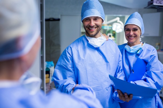 Cirurgiões que agitam a mão no quarto de operação