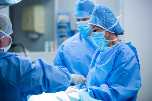 Cirurgiões que executam a operação no quarto de operação