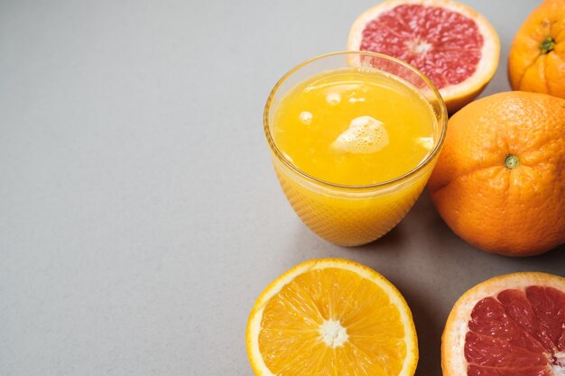 Citrus fatias de laranja e toranja com suco em fundo cinza com copyspace Vista superior plana leiga