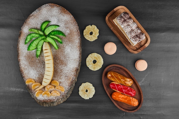 Éclairs com composição de frutas e fatia de tiramisu.