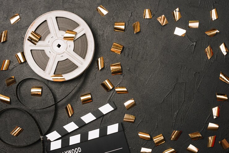 Foto grátis clapeiro aberto e bobina de filme sob confetes