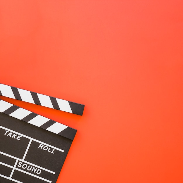 Foto grátis clapperboard em fundo vermelho com espaço na direita