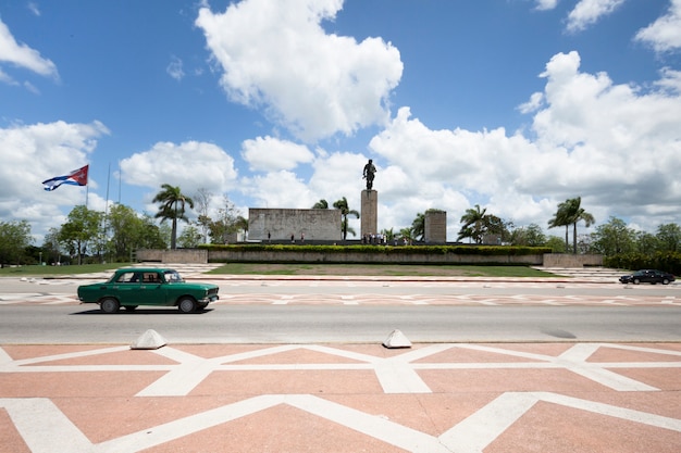 Classing car passing in front of monument em cuba