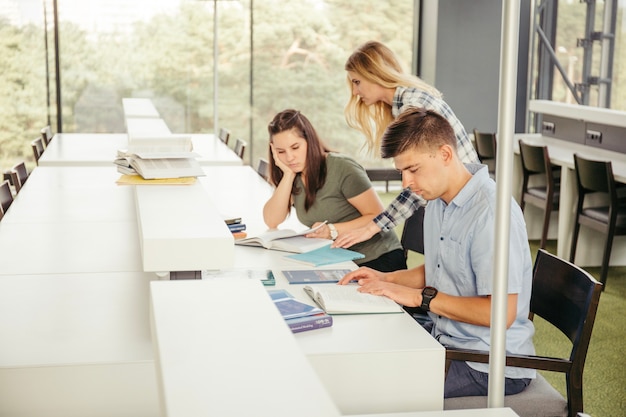 Classmates lendo na mesa na biblioteca