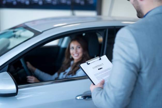 Cliente satisfeito comprando carro novo na concessionária