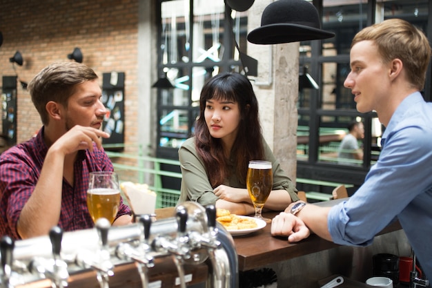 Clientes conversando com bartender no pub