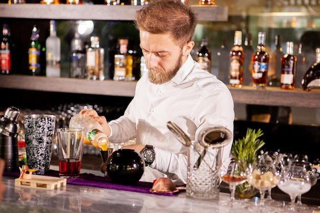 Foto grátis close das mãos do barman servindo bebida alcoólica.