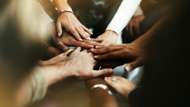 Close de diversas pessoas dando as mãos