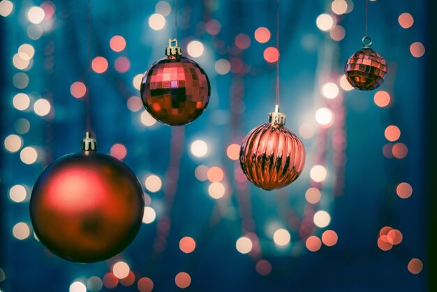 Close de enfeites coloridos em uma árvore de Natal com um fundo desfocado e luzes bokeh