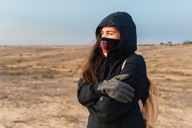 Close de foco raso de uma mulher se abraçando por causa do tempo frio