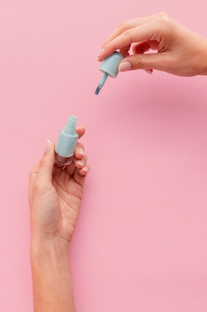 Close de mãos segurando esmalte azul