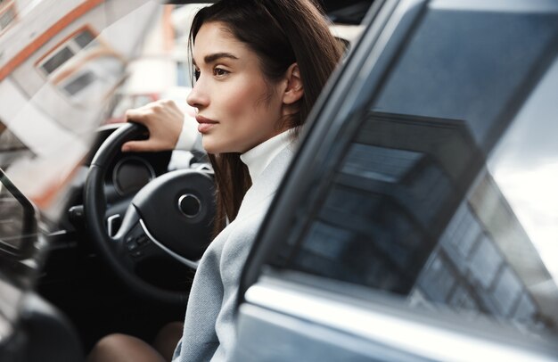 Close de mulher de negócios elegante entrando no carro para ir para o trabalho