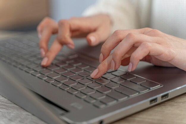 Close de mulher digitando em um laptop