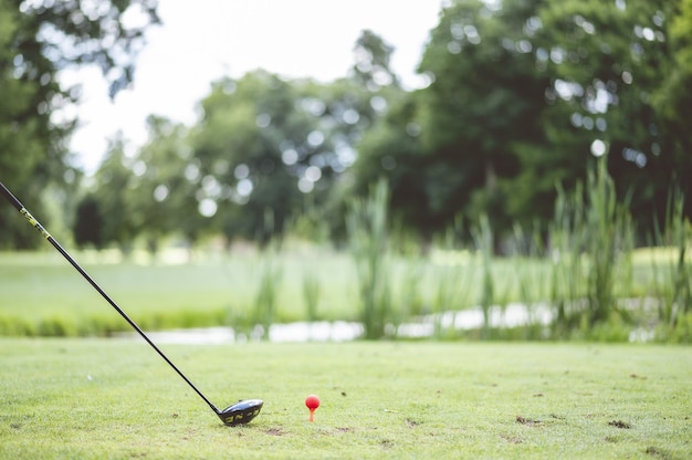 Close de um atleta jogando golfe em um clube de golfe em um campo coberto de grama