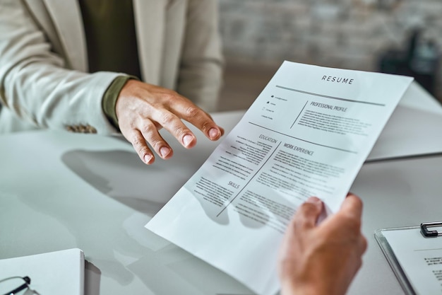 Close de um candidato dando seu CV ao se candidatar a um emprego no escritório