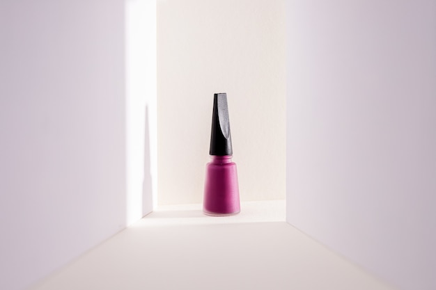 Close de um esmalte roxo contra um branco