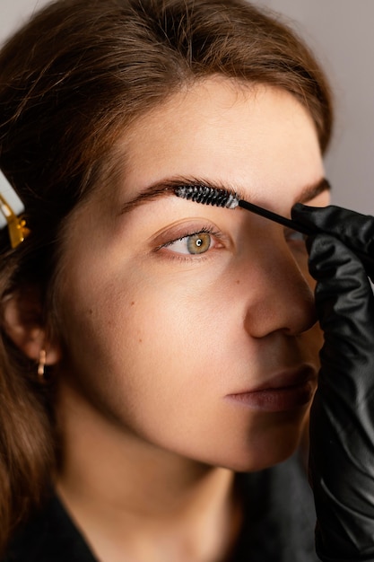 Close de uma especialista feminina fazendo um tratamento de sobrancelha para uma mulher