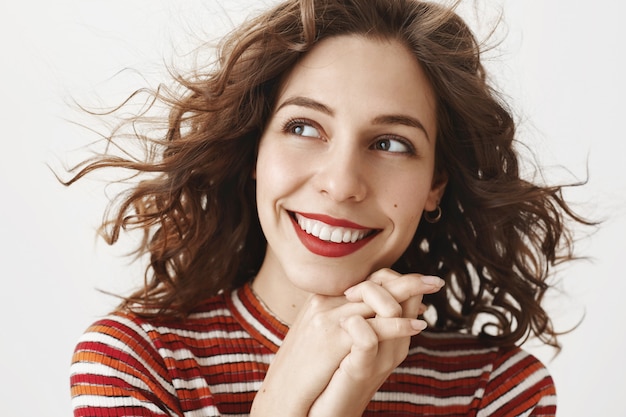 Foto grátis close de uma mulher adorável e romântica sorrindo e parecendo sonhadora