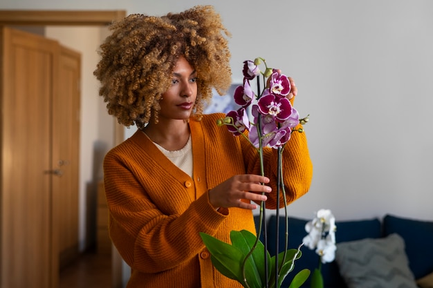 Close de uma mulher decorando sua casa com orquídeas
