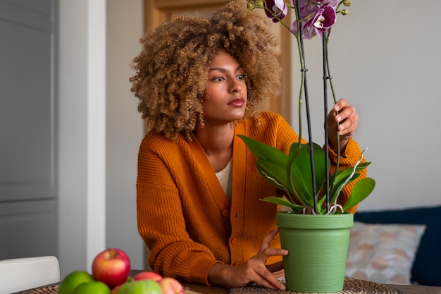 Foto grátis close de uma mulher decorando sua casa com orquídeas