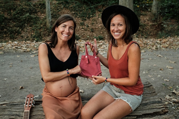 Close de uma mulher grávida trocando uma pequena bolsa rosa