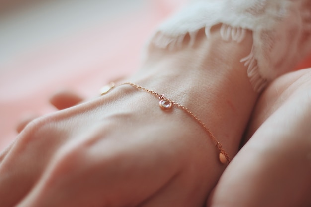 Close de uma mulher usando uma pulseira da moda com pingentes de pingente