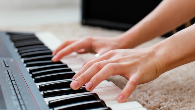 Close de uma musicista tocando teclado de piano