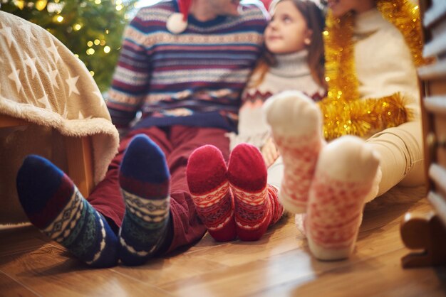 Close dos pés da família em meias de lã