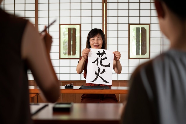 Close na pessoa fazendo caligrafia japonesa, chamada shodo
