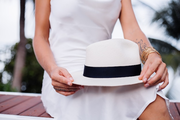 Close-shot mulher em um vestido de seda com chapéu branco clássico