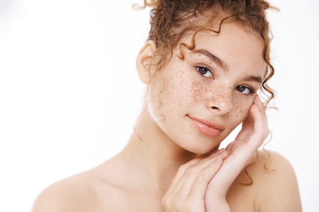 Close-up atraente nua delicada mulher ruiva sardas tocar a pele com ternura sorrindo câmera aliviada sensualmente, condição de pele limpa realizada, levar estilo de vida ativo saudável beleza autêntica