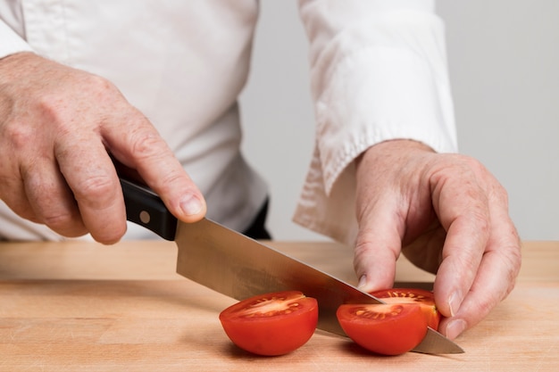 Close-up chef cortar tomates