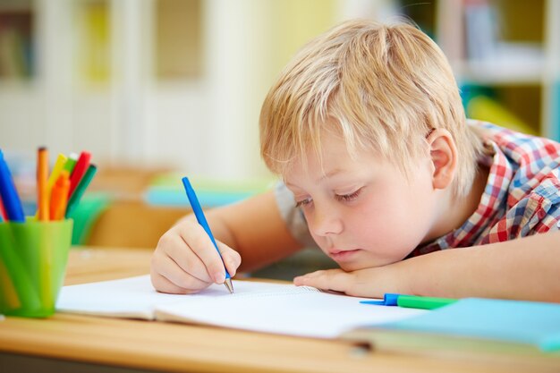 Close-up da aprendizagem do aluno primário para escrever