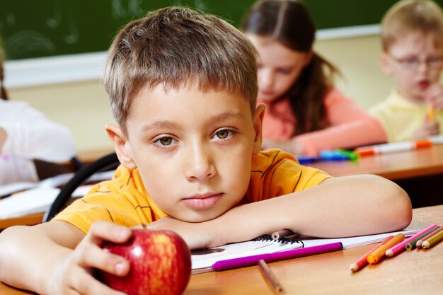 Close-up da criança entediada com uma maçã