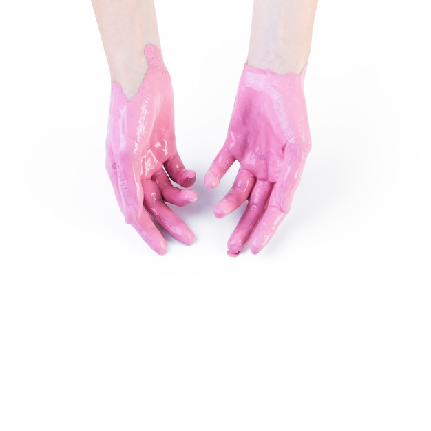 Close-up da mão de uma mulher com tinta rosa em fundo branco