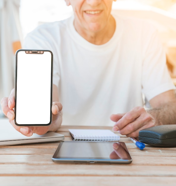 Foto grátis close-up da mão do homem, mostrando smartphone com tela branca