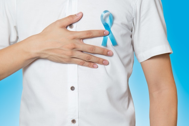 Close-up da mão masculina, apontando para a luz da fita azul para prostat