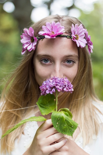 Foto grátis close-up da menina que cheira uma flor