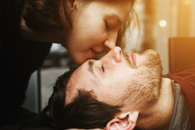Close-up da mulher beijando o rosto de seu namorado