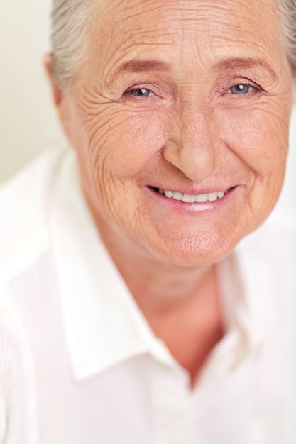 Close-up da mulher idosa com rugas no rosto