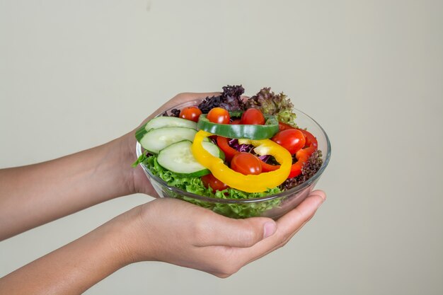 Close-up das mãos segurando uma taça de salada