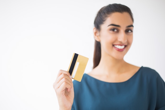 Close up de borrada mulher agradável cartão de crédito mostrando