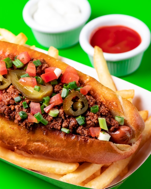 Foto grátis close-up de cachorro-quente com cebolinha de tomate carne picada e jalapeno em conserva